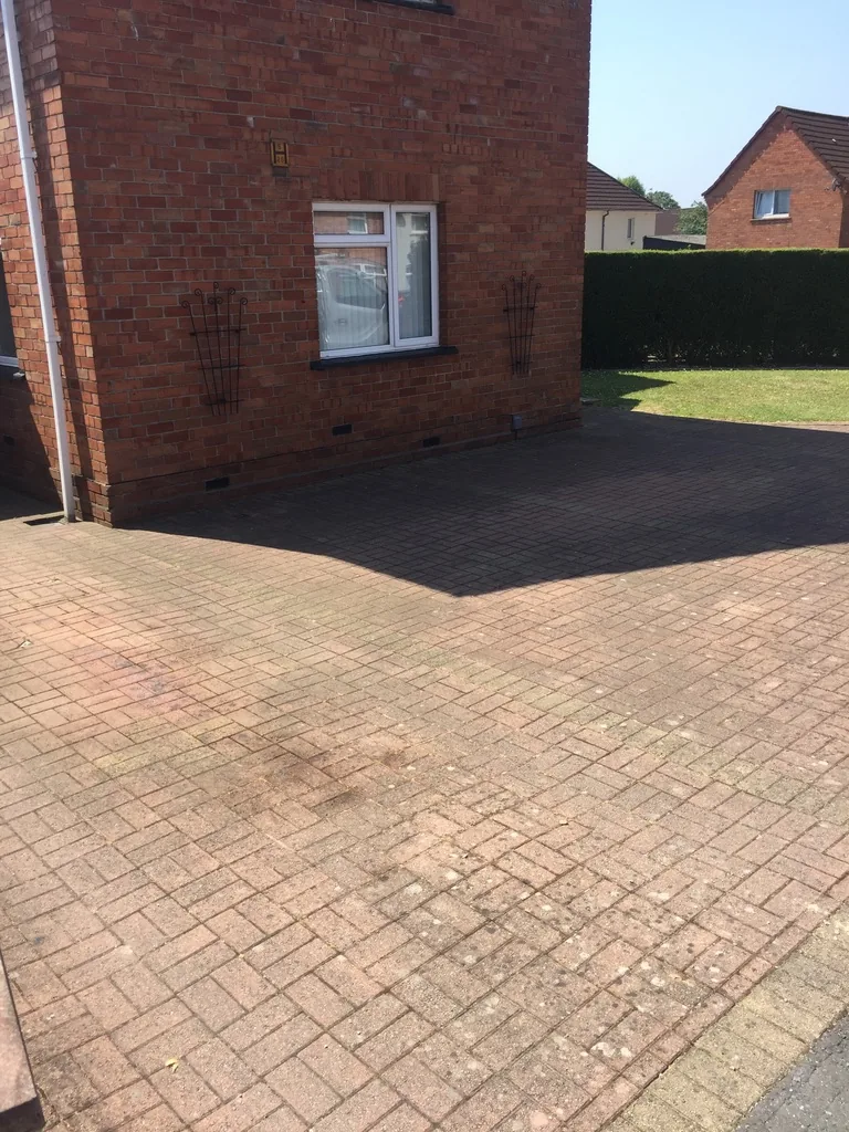 Driveway block paving covered in moss, weeds and lichen before professional pressure washing in Knowle, Bristol.